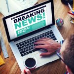 stock-photo-man-with-laptop-reading-news